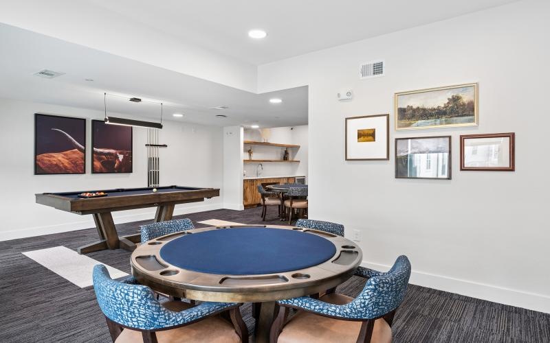 a room with a pool table and chairs