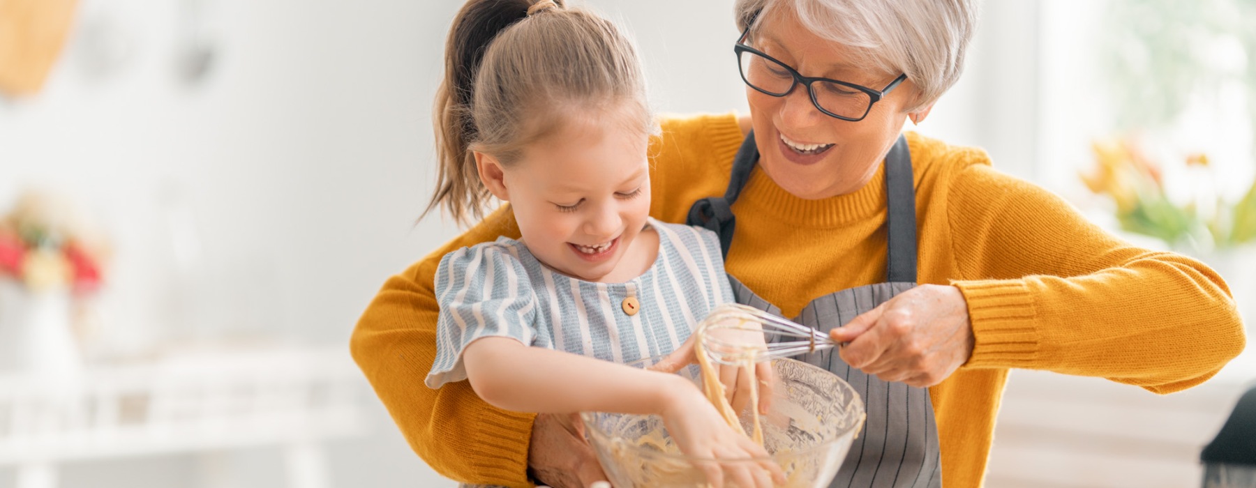 a grandmother and her grand-daughter baking