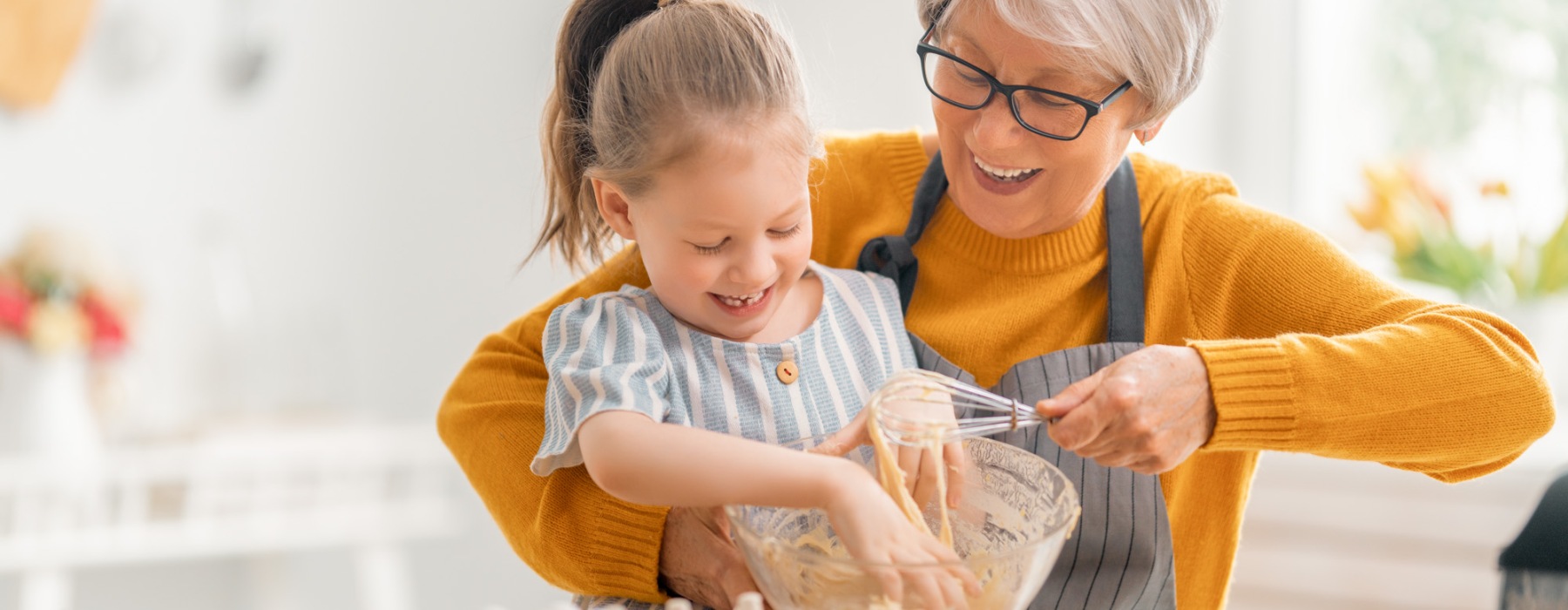 a grandmother and her grand-daughter baking