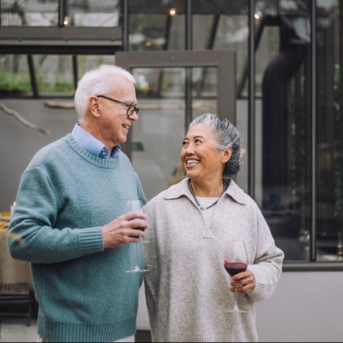 man and woman walking and drinking wine